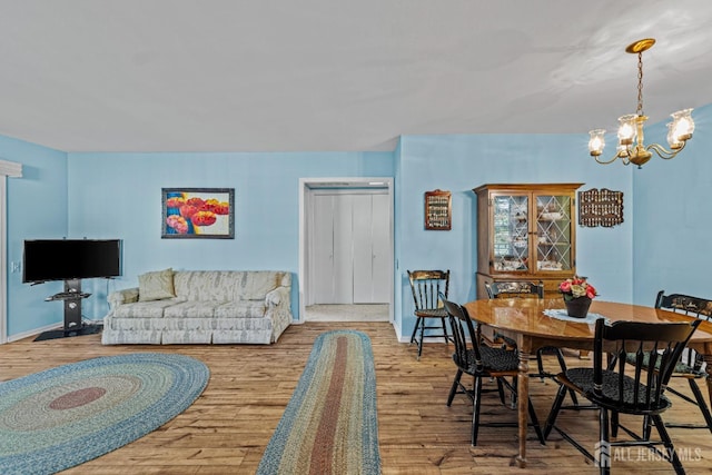 interior space with baseboards, wood finished floors, and an inviting chandelier