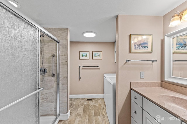 full bathroom with wood finished floors, a shower stall, vanity, and baseboards