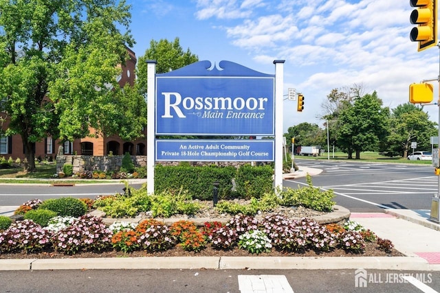 community / neighborhood sign featuring uncovered parking