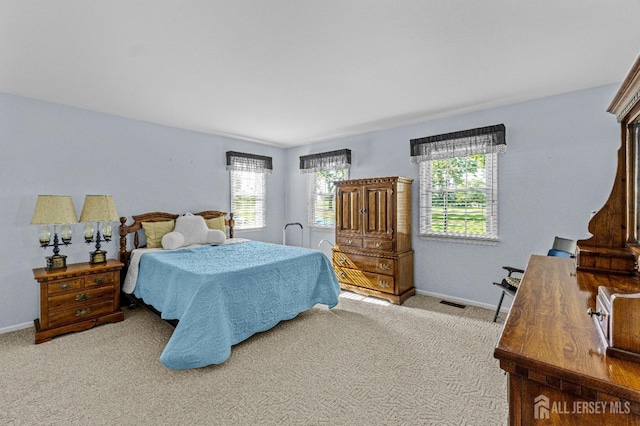 carpeted bedroom featuring visible vents and baseboards