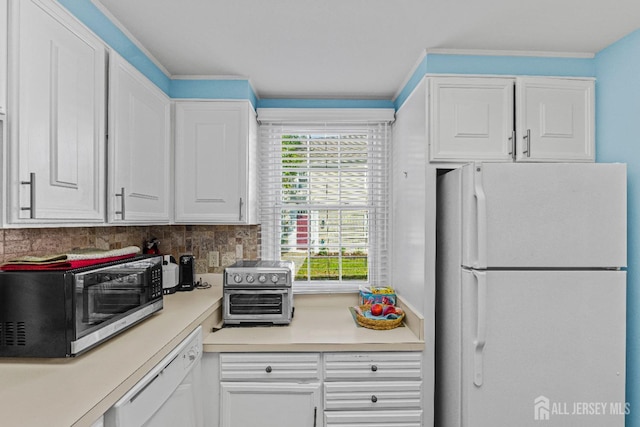 kitchen featuring white appliances, white cabinets, light countertops, ornamental molding, and backsplash