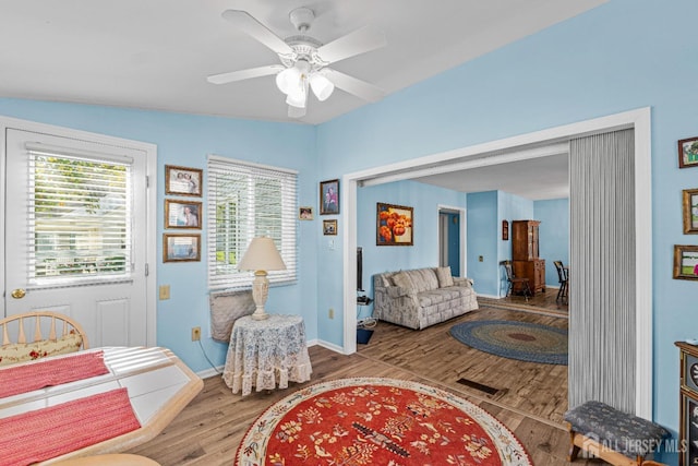 sitting room featuring baseboards, a ceiling fan, and wood finished floors