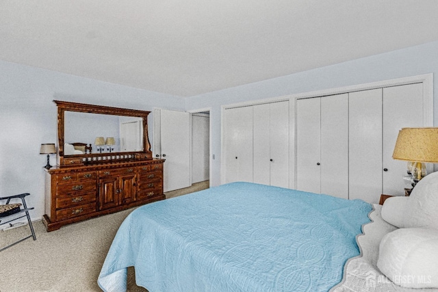 carpeted bedroom with multiple closets