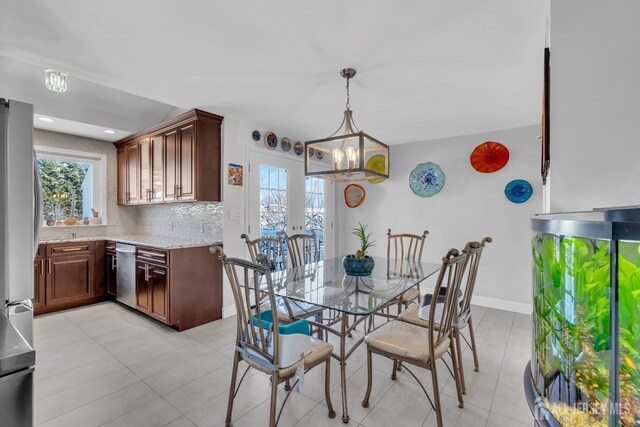 tiled dining area featuring a chandelier