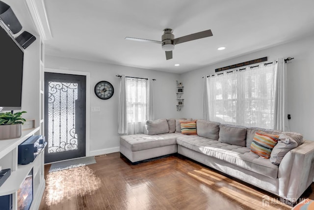 living room featuring ceiling fan and dark hardwood / wood-style floors