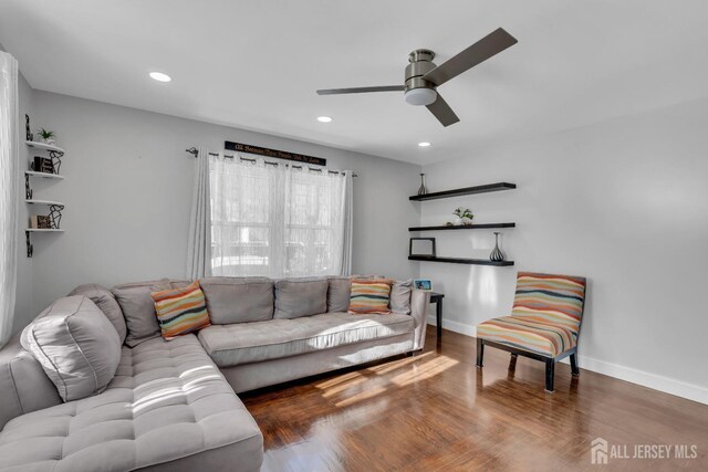 living room with dark wood-type flooring and ceiling fan