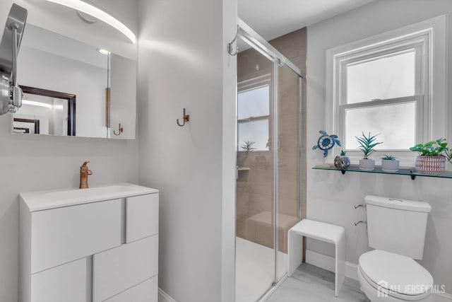 bathroom featuring vanity, toilet, and a shower with door