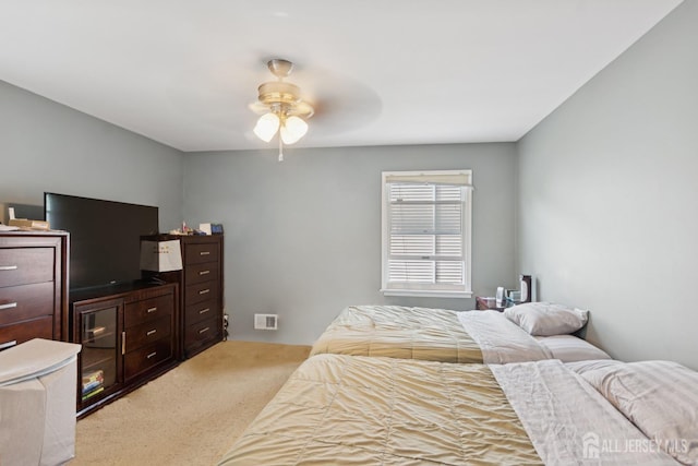 bedroom with light carpet and a ceiling fan
