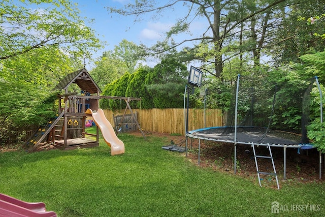 view of jungle gym featuring a trampoline, a yard, and a fenced backyard
