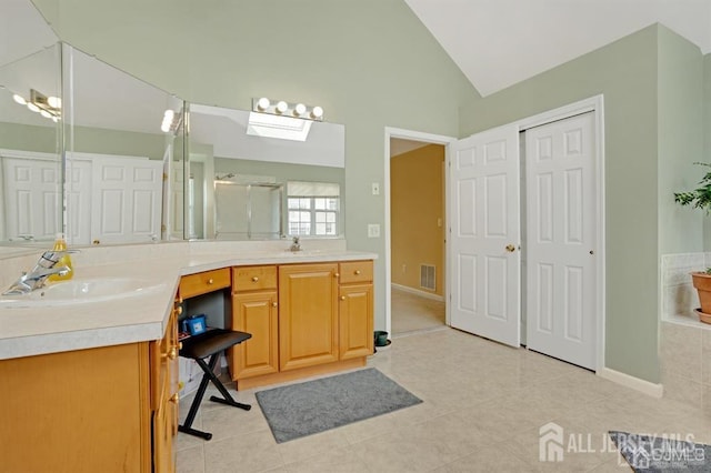 65 Cortland Dr, East Brunswick, NJ 08816 - bathroom with double vanity, vaulted ceiling, tile patterned flooring, a shower with shower door, and a skylight
