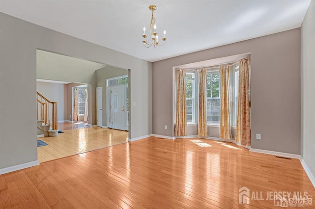 65 Cortland Dr, East Brunswick, NJ 08816 - unfurnished room with stairway, hardwood / wood-style floors, and a chandelier