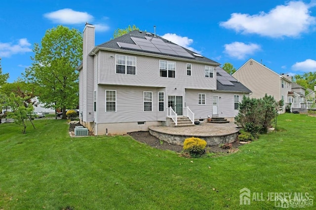 65 Cortland Dr, East Brunswick, NJ 08816 - rear view of house with roof mounted solar panels, a chimney, a yard, and entry steps