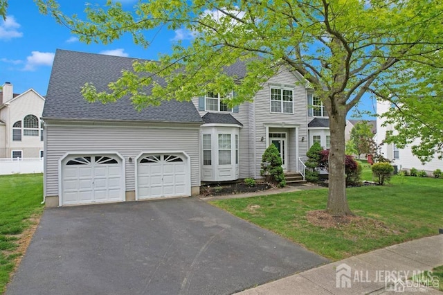 65 Cortland Dr, East Brunswick, NJ 08816 - traditional-style home featuring asphalt driveway, a front yard, a garage, and a shingled roof