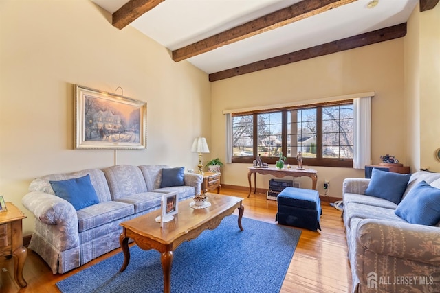 living area featuring light wood finished floors and beamed ceiling