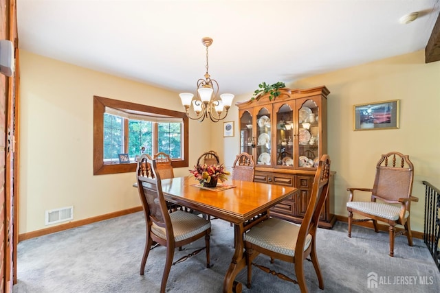 dining space featuring baseboards, visible vents, a notable chandelier, and carpet flooring