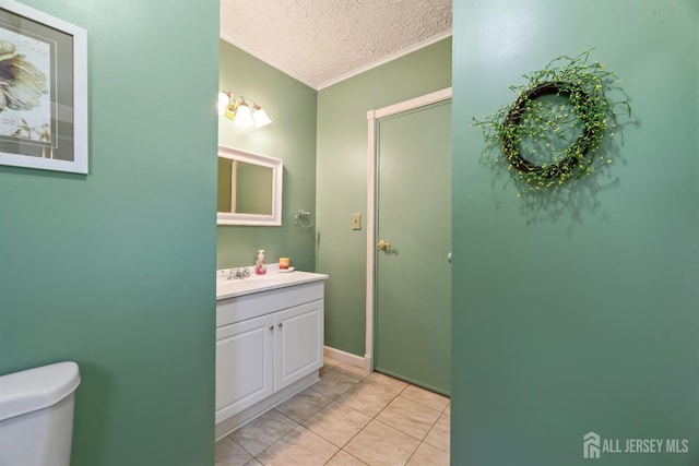 bathroom with vanity, tile patterned floors, toilet, ornamental molding, and a textured ceiling