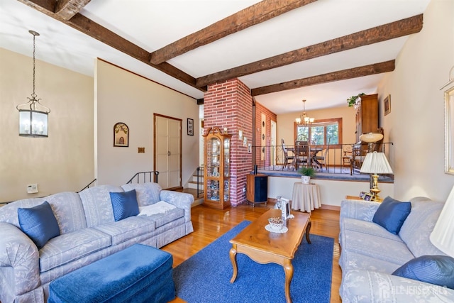 living room with beam ceiling, stairway, wood finished floors, and a notable chandelier