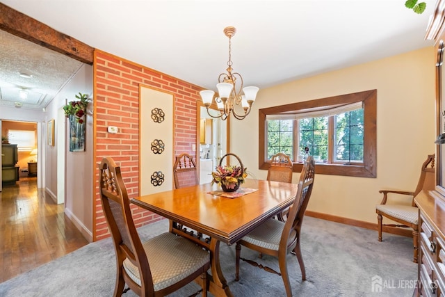 dining room featuring a chandelier, baseboards, and light wood-type flooring