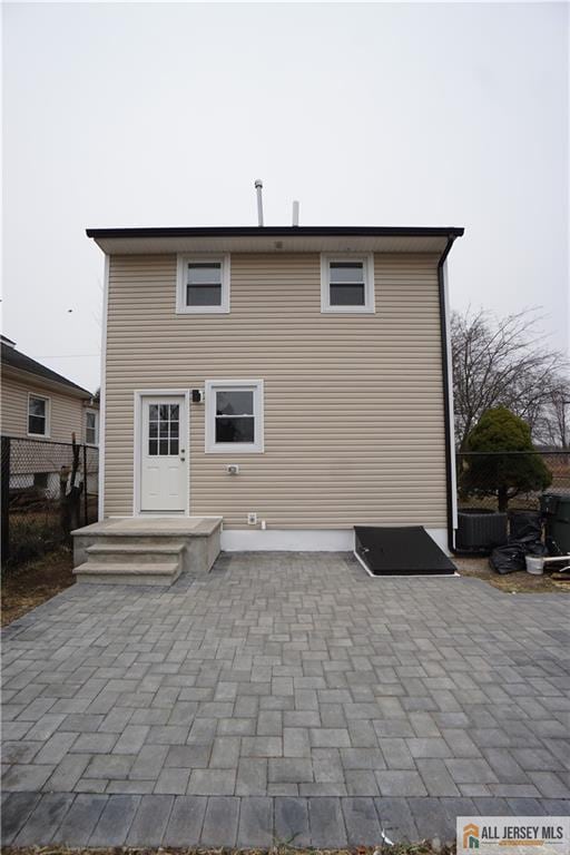 rear view of property featuring a patio and fence