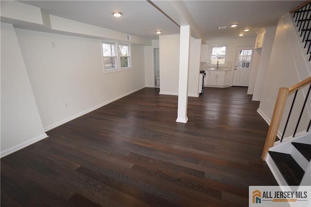 below grade area with recessed lighting, baseboards, dark wood finished floors, and stairs