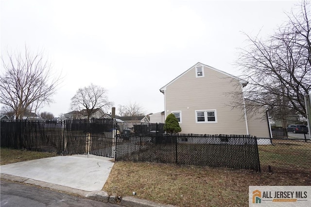 view of side of home featuring a gate and fence