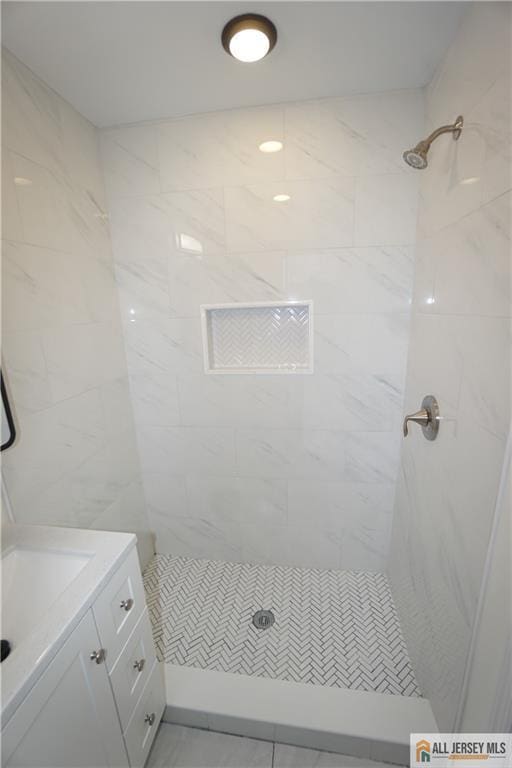 bathroom with vanity and tiled shower