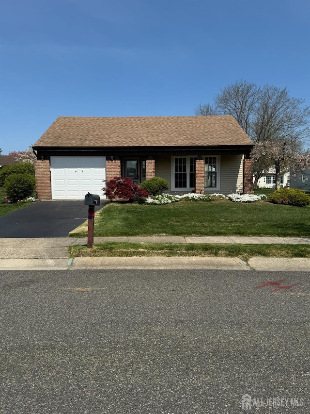 93 Mansfield Ave, Manchester, NJ 08579 - view of front facade featuring driveway, an attached garage, brick siding, and a front yard