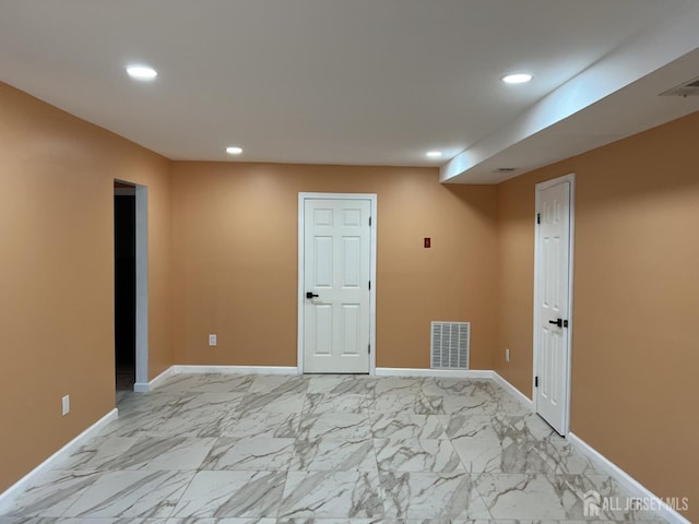 spare room featuring recessed lighting, visible vents, marble finish floor, and baseboards