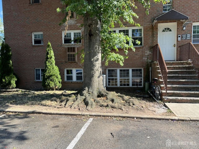 view of front of home with brick siding and uncovered parking