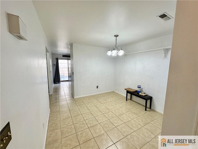 unfurnished dining area with light tile patterned floors and a notable chandelier