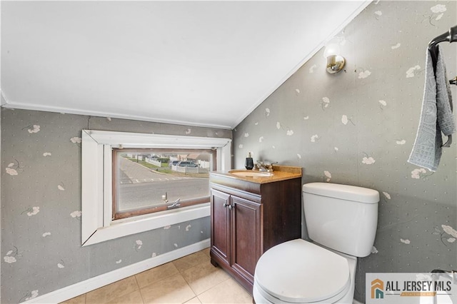 bathroom with toilet, tile patterned flooring, ornamental molding, vanity, and baseboards