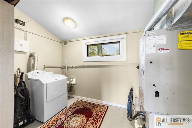 clothes washing area with washer / dryer, baseboards, and heating unit