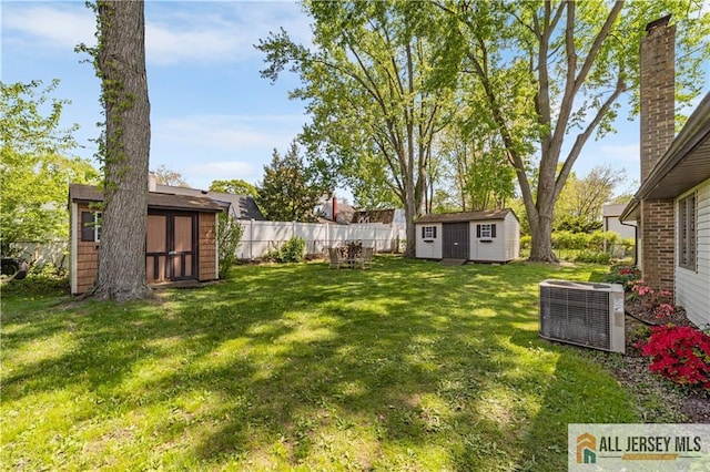 view of yard featuring a storage shed, cooling unit, and an outdoor structure