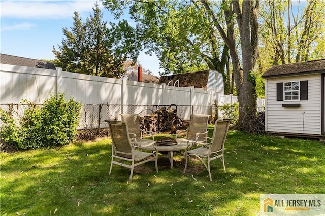 view of yard with an outdoor fire pit, an outbuilding, and a storage shed