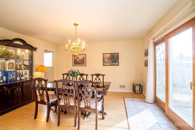 dining room featuring light wood-type flooring and a notable chandelier