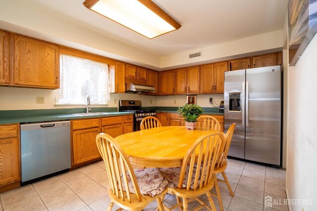 kitchen featuring light tile patterned flooring, appliances with stainless steel finishes, and sink