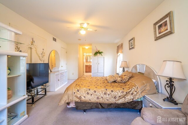 bedroom featuring ceiling fan, carpet, and ensuite bath