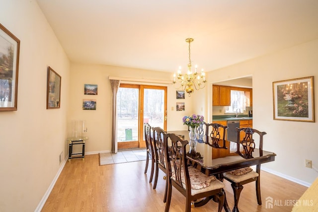 dining area with sink, light hardwood / wood-style flooring, and a chandelier