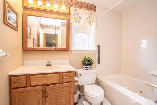 full bathroom featuring toilet, vanity, and tiled shower / bath combo