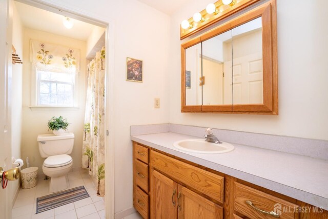 bathroom featuring tile patterned floors, vanity, and toilet