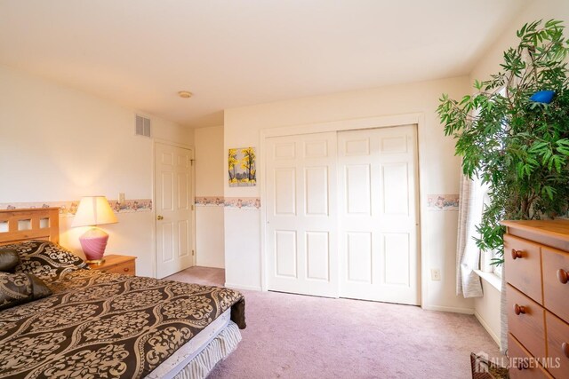 bedroom with light carpet and a closet