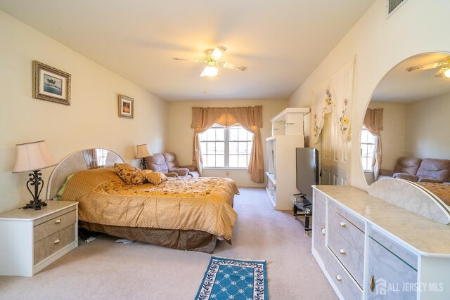 carpeted bedroom featuring ceiling fan and multiple windows