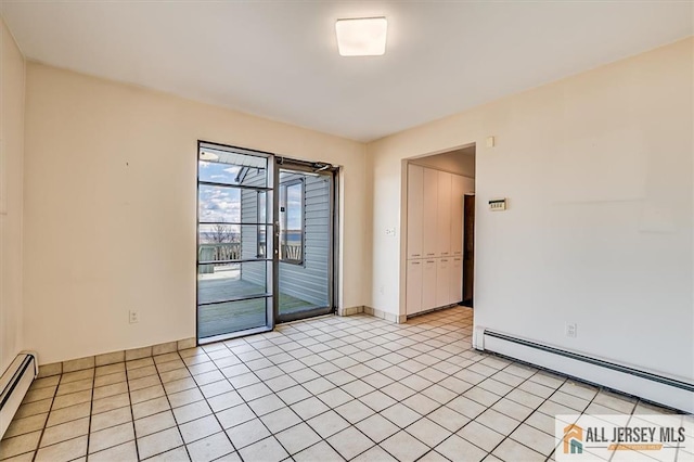 spare room with light tile patterned floors, a baseboard radiator, and baseboards