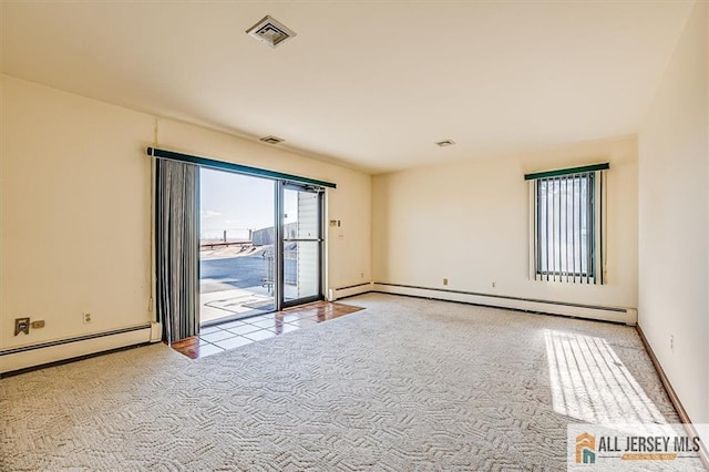 carpeted spare room featuring visible vents, baseboards, and a baseboard heating unit