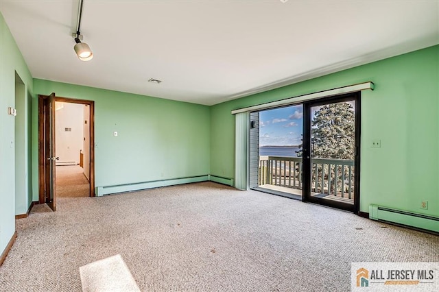 empty room with a baseboard heating unit, visible vents, carpet floors, and a baseboard radiator