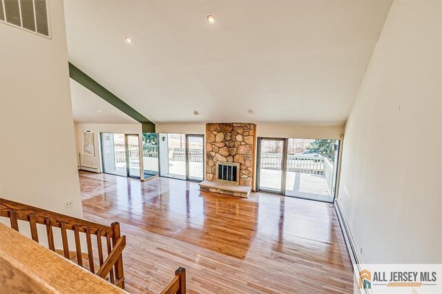 living room featuring light wood finished floors, visible vents, plenty of natural light, and a fireplace