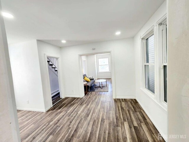 corridor with dark wood-type flooring and plenty of natural light