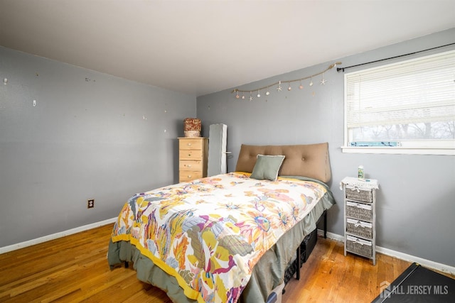 bedroom featuring baseboards and wood finished floors