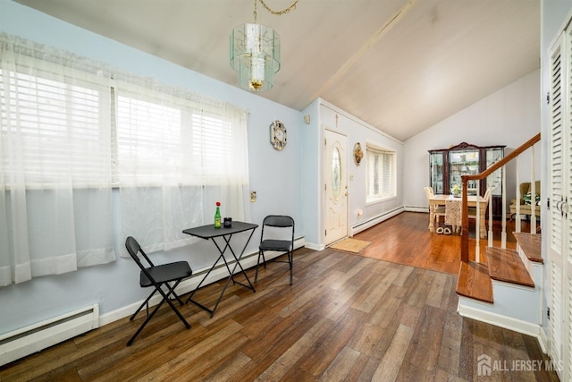 foyer entrance with a baseboard radiator, lofted ceiling, and wood finished floors