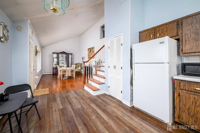 kitchen with baseboards, freestanding refrigerator, tile counters, high vaulted ceiling, and dark wood-type flooring
